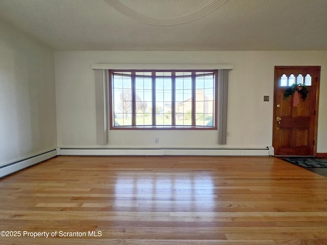 foyer with baseboard heating and wood finished floors