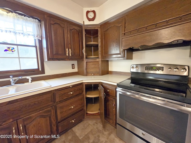 kitchen with electric range, light countertops, and a sink