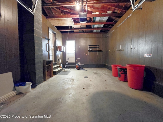 garage with wood walls and a garage door opener