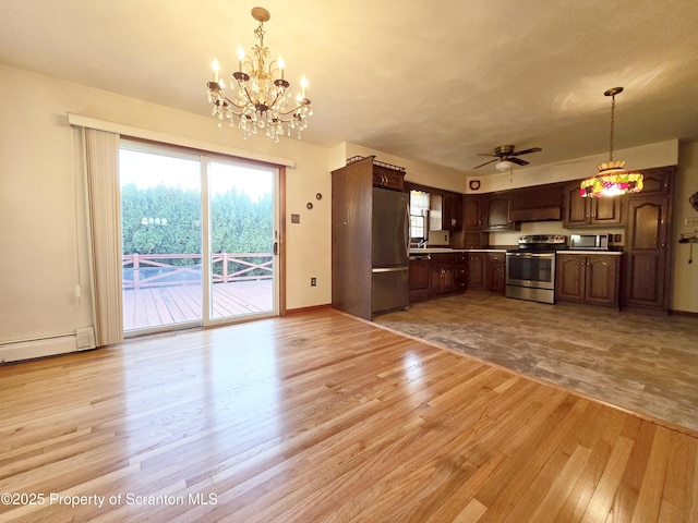 kitchen with stainless steel appliances, a wealth of natural light, hanging light fixtures, and light wood finished floors