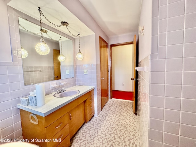 bathroom with a wainscoted wall, tile walls, and vanity