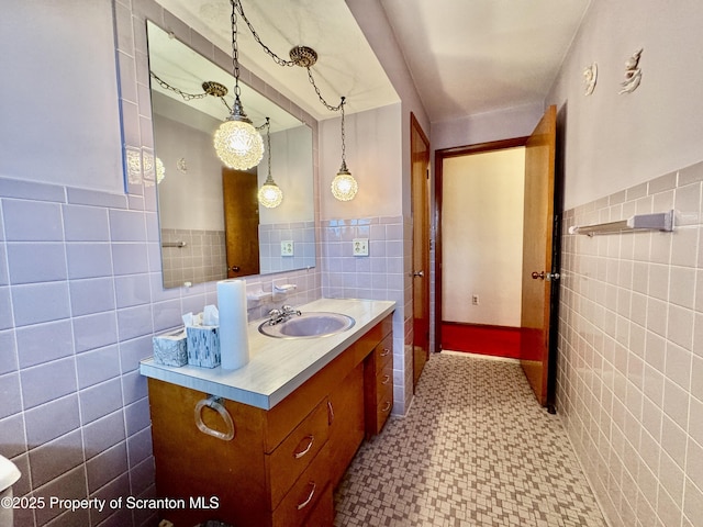 bathroom with wainscoting, tile walls, and vanity