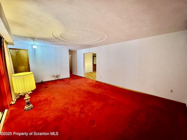 carpeted empty room featuring radiator heating unit