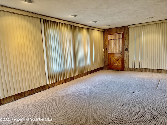 spare room featuring a textured ceiling and carpet floors