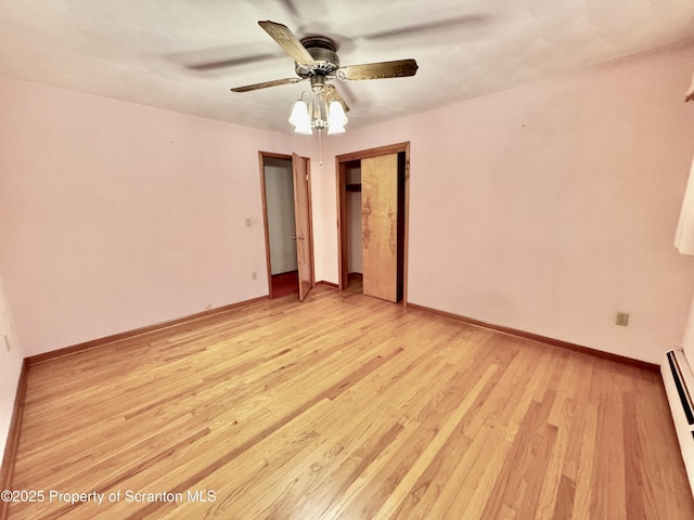 unfurnished room featuring light wood-style floors, baseboard heating, ceiling fan, and baseboards