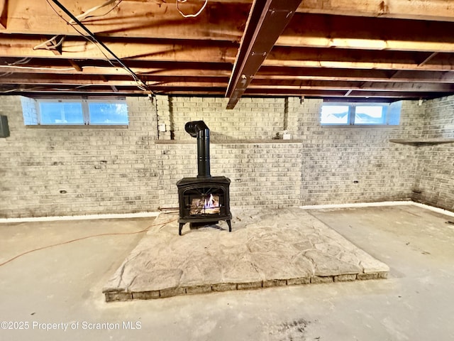 below grade area with a wood stove and brick wall