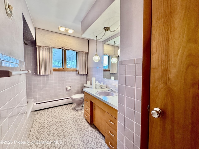 bathroom featuring a baseboard radiator, toilet, a wainscoted wall, vanity, and tile walls