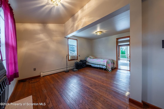 unfurnished bedroom featuring hardwood / wood-style floors and baseboard heating