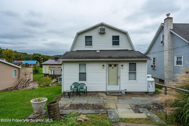 back of house featuring a lawn and a patio area