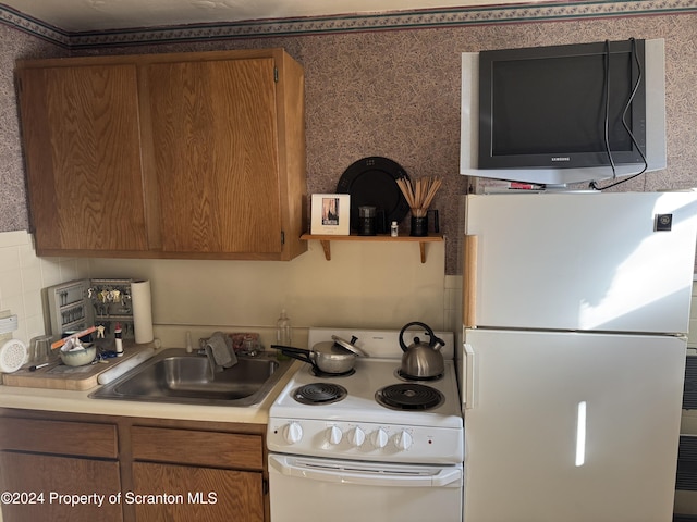 kitchen with backsplash, sink, and white appliances