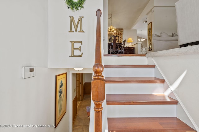 staircase featuring a notable chandelier