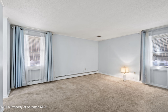 carpeted empty room featuring a baseboard heating unit and a textured ceiling