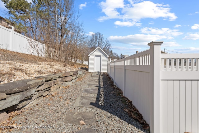 view of yard with an outdoor structure, a storage shed, and a fenced backyard