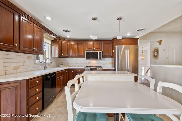 kitchen with a sink, light countertops, visible vents, and stainless steel appliances