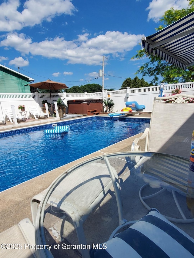 view of pool with a patio area, a fenced in pool, a hot tub, and a fenced backyard