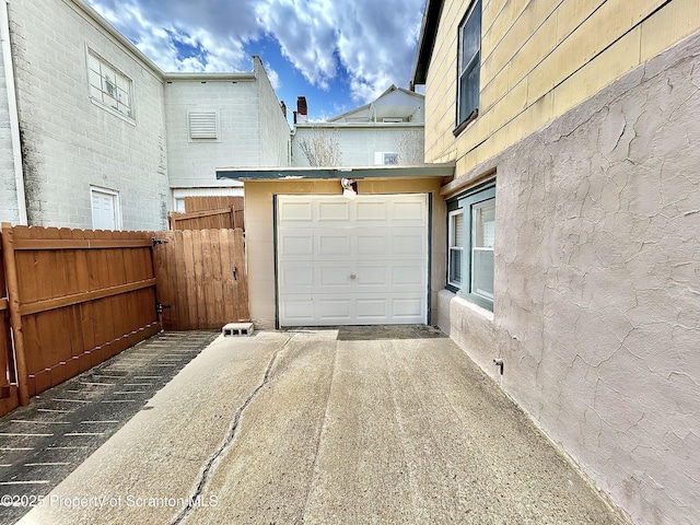 garage with fence and driveway