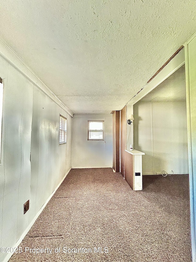 carpeted spare room featuring a textured ceiling and ornamental molding