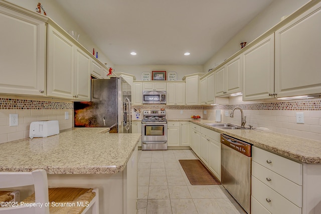 129 Wyndham Rd, South Abington Twp, PA 18411 - kitchen with appliances with stainless steel finishes, decorative backsplash, a peninsula, light tile patterned floors, and recessed lighting