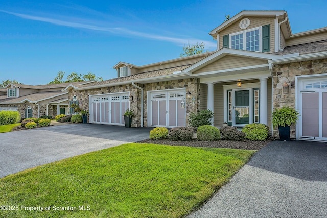 129 Wyndham Rd, South Abington Twp, PA 18411 - view of front of property with stone siding, asphalt driveway, and an attached garage