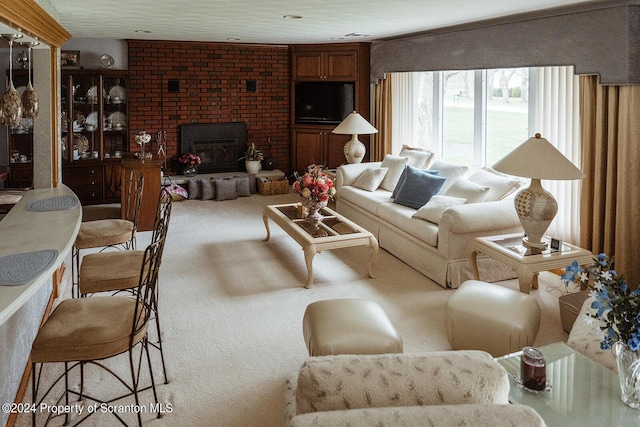 carpeted living room with a brick fireplace