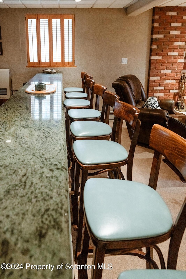 dining room with carpet and a paneled ceiling