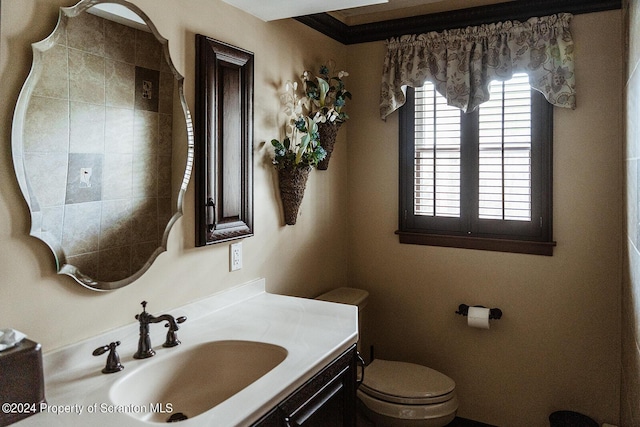 bathroom with vanity, toilet, and ornamental molding