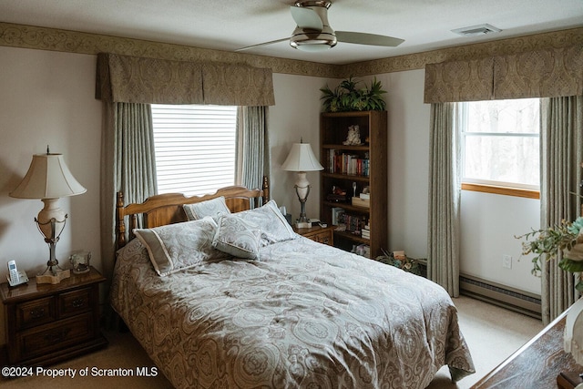 carpeted bedroom featuring baseboard heating and ceiling fan