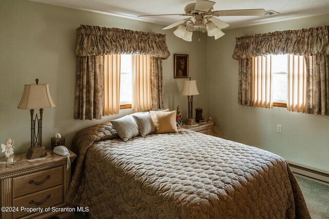 carpeted bedroom with a baseboard radiator and ceiling fan