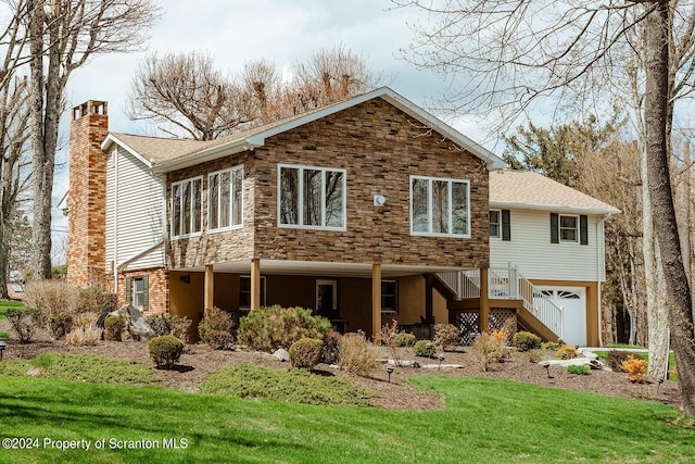 rear view of house featuring a yard and a garage