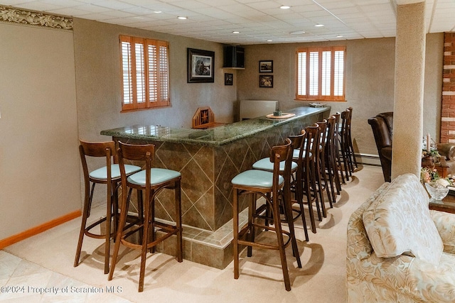 bar with a paneled ceiling and a baseboard radiator