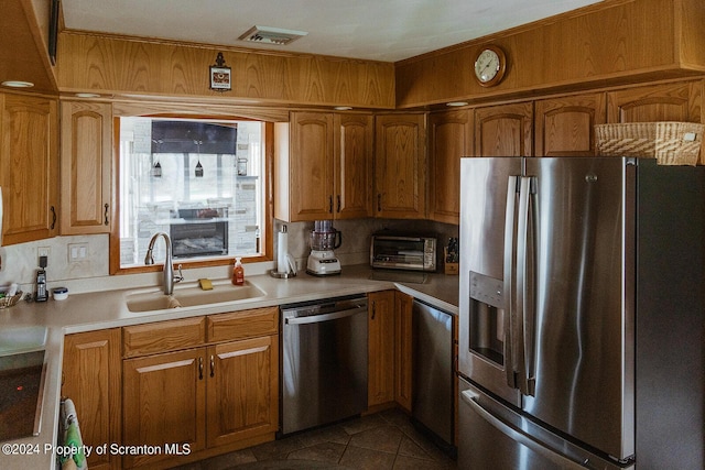 kitchen featuring dark tile patterned floors, sink, and appliances with stainless steel finishes