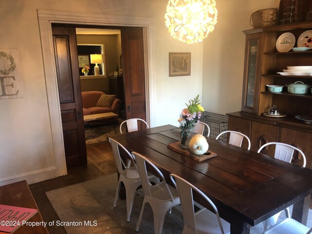 dining room with dark hardwood / wood-style floors and an inviting chandelier