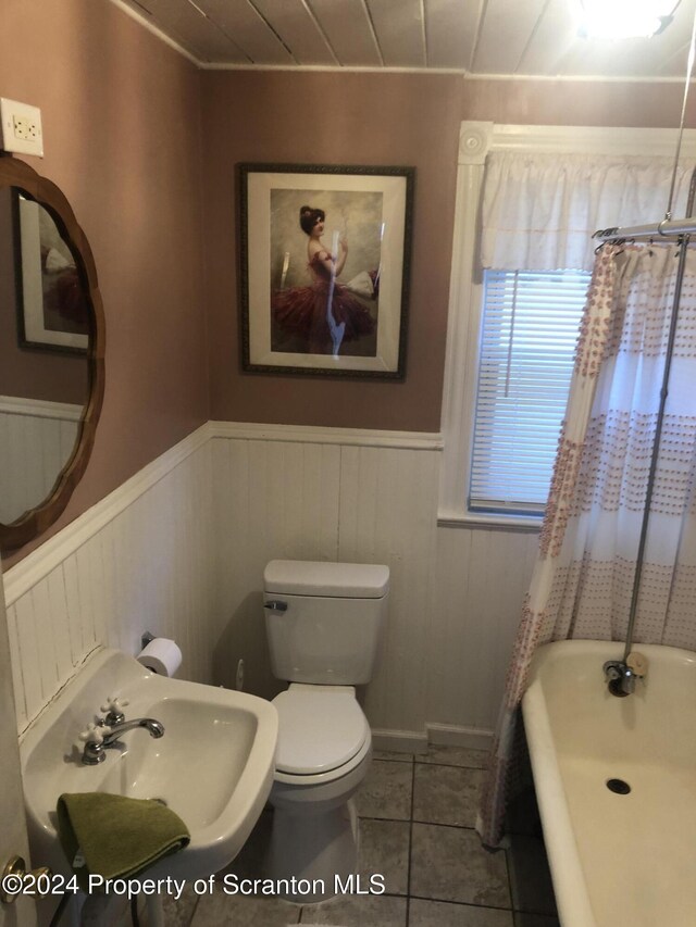 bathroom with toilet, a washtub, tile patterned flooring, and sink