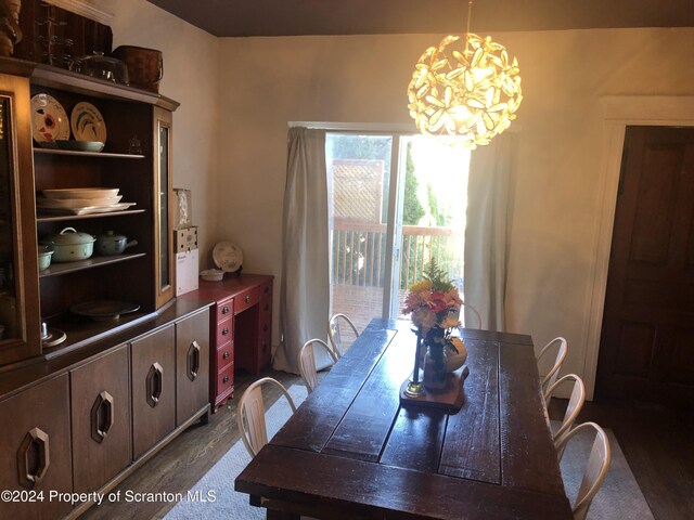 dining room with dark hardwood / wood-style flooring and an inviting chandelier