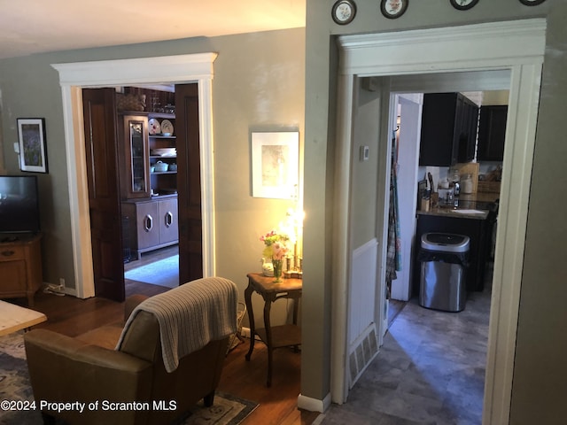 hall with sink, dark wood-type flooring, and washing machine and clothes dryer