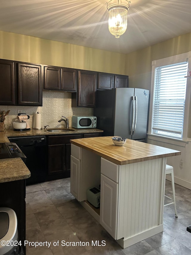 825 Prescott Ave, Scranton, PA 18510 - kitchen featuring stainless steel appliances, butcher block counters, tasteful backsplash, dark brown cabinetry, and a center island