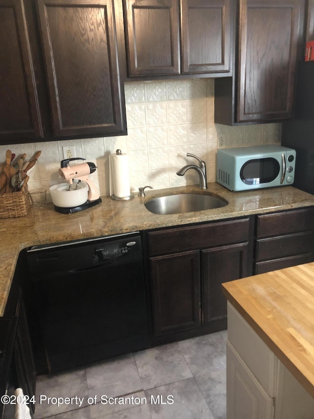 kitchen featuring dishwasher, wooden counters, sink, decorative backsplash, and dark brown cabinetry