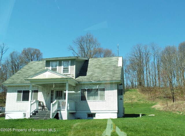 75 Hamlin Hwy, Moscow, PA 18444 - bungalow-style home with covered porch, a front lawn, brick siding, and roof with shingles