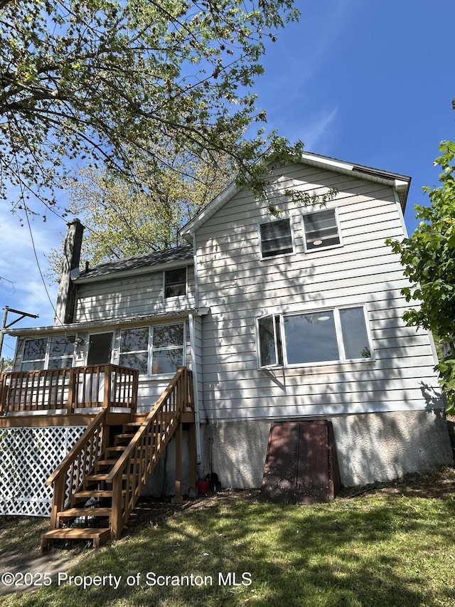 210 Gorham Ave, Mayfield, PA 18433 - rear view of house with stairs, a wooden deck, a chimney, and a lawn