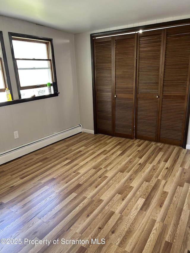 210 Gorham Ave, Mayfield, PA 18433 - unfurnished bedroom with a baseboard heating unit, light wood finished floors, and a closet