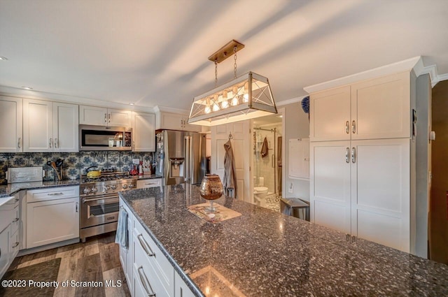 266 Warren Park Rd, New Milford, PA 18834 - kitchen featuring appliances with stainless steel finishes, dark wood finished floors, backsplash, hanging light fixtures, and dark stone counters