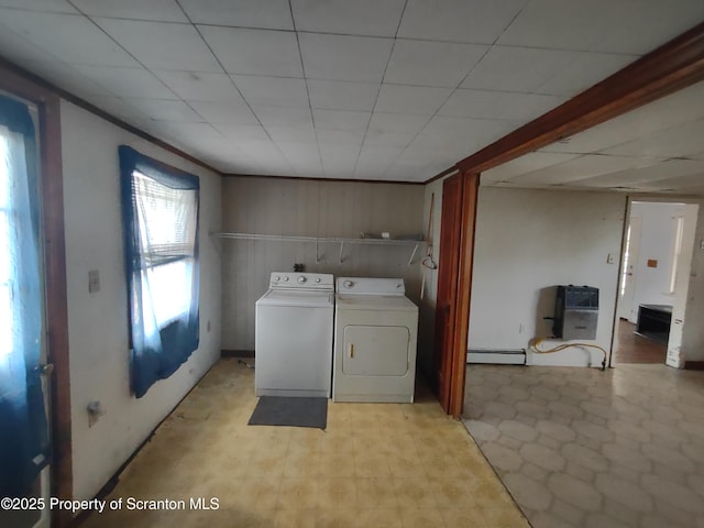 laundry area featuring light floors, a baseboard radiator, laundry area, and separate washer and dryer