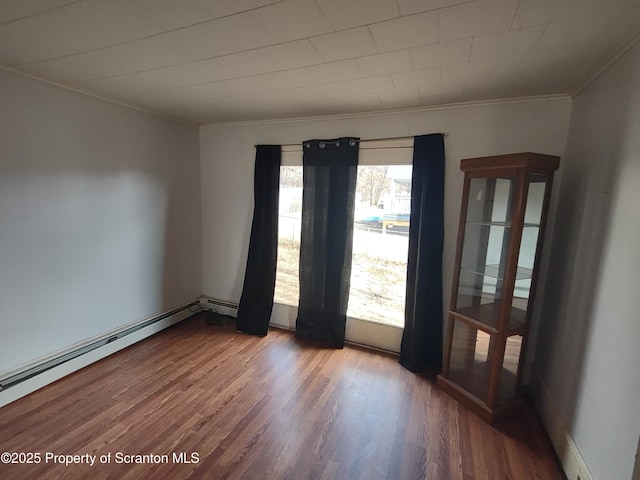 unfurnished room featuring ornamental molding, a baseboard radiator, and wood finished floors