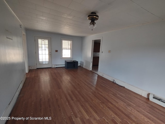 unfurnished living room featuring a baseboard radiator, baseboards, and wood finished floors