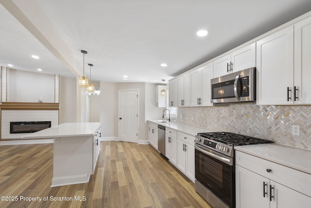 828 Lake Henry Rd, Lake Ariel, PA 18436 - kitchen with backsplash, stainless steel appliances, light wood-style flooring, and white cabinetry