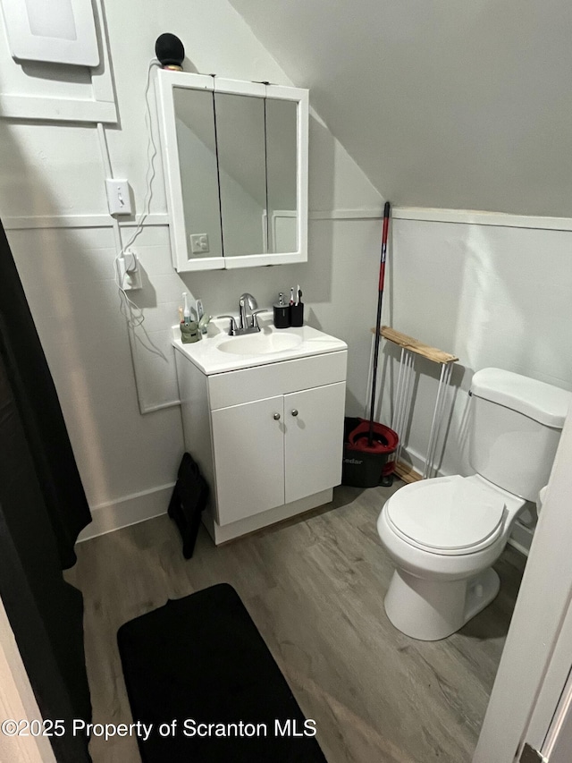 717719 Cedar Ave, Scranton, PA 18505 - bathroom with wood finished floors, toilet, vanity, vaulted ceiling, and baseboards