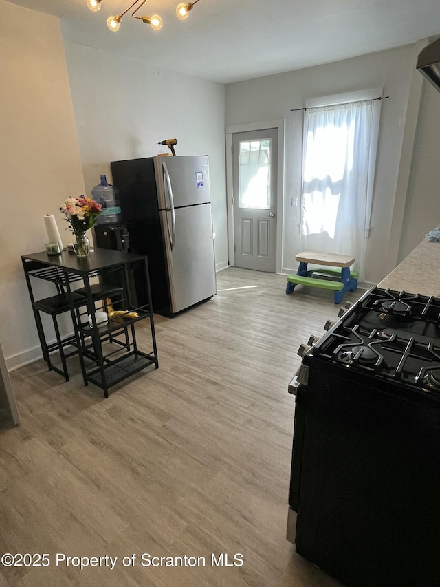 717719 Cedar Ave, Scranton, PA 18505 - kitchen featuring black range with gas cooktop, freestanding refrigerator, light wood finished floors, and baseboards