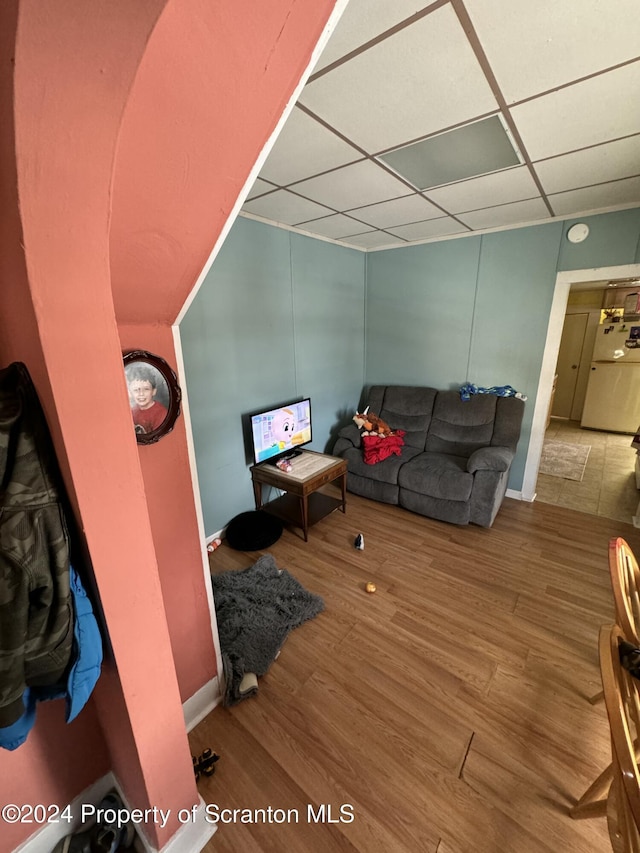 living room with hardwood / wood-style flooring and a paneled ceiling