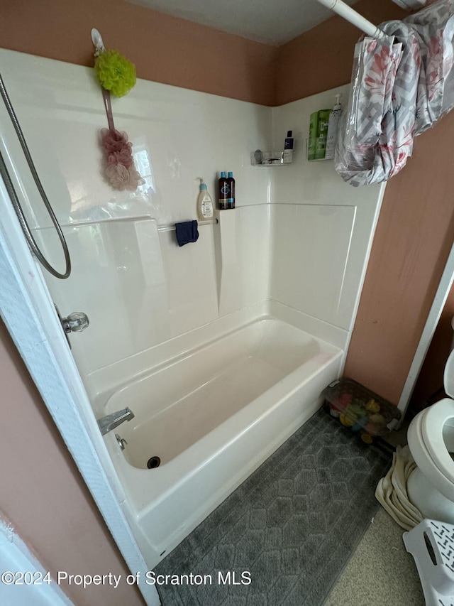 bathroom with toilet and washtub / shower combination