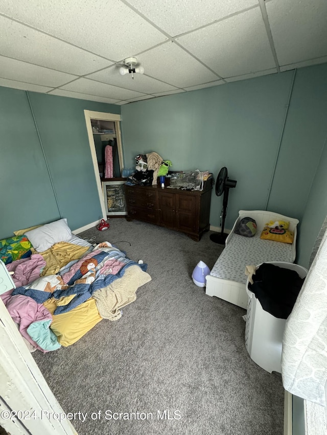 carpeted bedroom featuring a drop ceiling